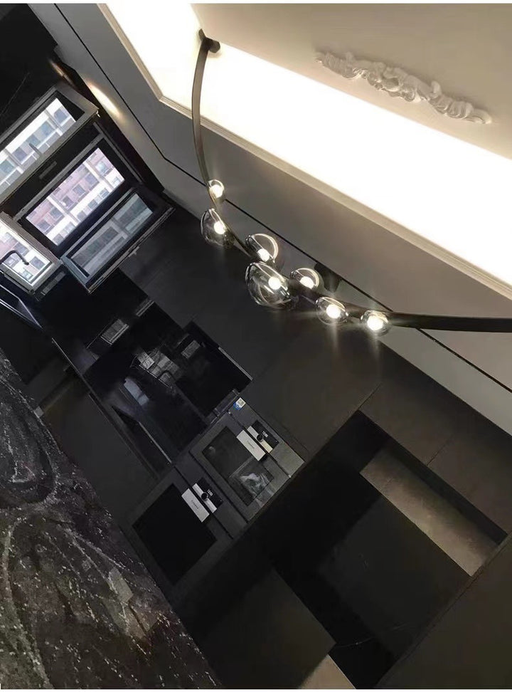 Suspension design en cuir et sphères lumineuses diffusant une lumière tamisée dans un décor feutré.