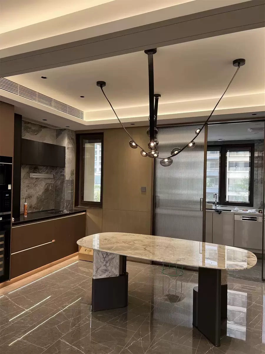 Vue grand angle d'une suspension en cuir et sphères lumineuses dans un espace de vie haut de gamme.