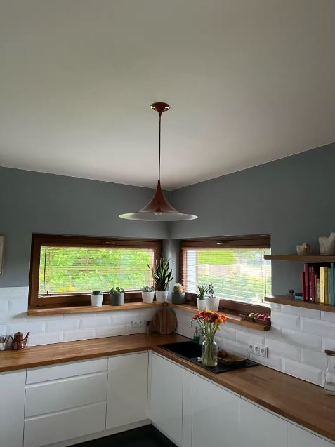 Suspension cuivrée à silhouette effilée dans une cuisine, entre esprit mid-century, design moderne et touche vintage.