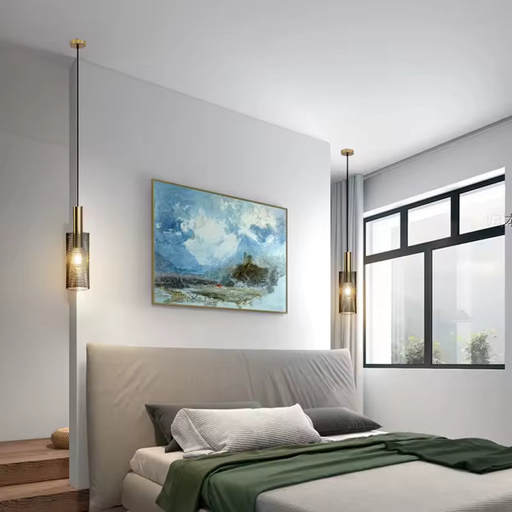 Luminaire suspendu cylindrique en métal ajouré noir et doré, idéal pour une chambre moderne et élégante