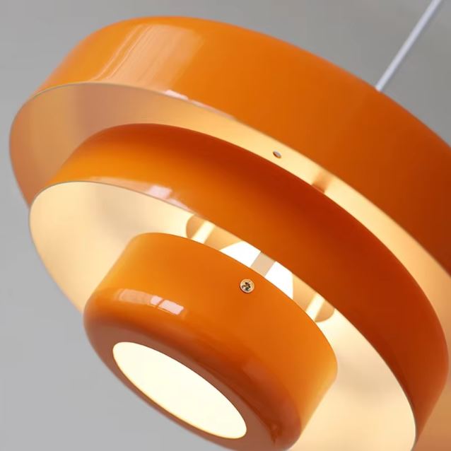 Zoom sur une suspension danoise orange au design vintage, mettant en valeur ses courbes iconiques et sa finition brillante.