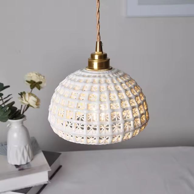 Suspension Dentelle de Céramique ajourée blanche diffusant une lumière douce, parfaite pour un intérieur romantique, vintage doux ou maison de charme.