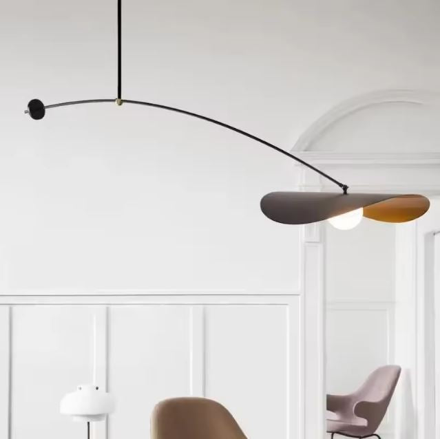 Suspension déportée noire à bras courbé, avec abat-jour sculptural noir et doré et allure contemporaine raffinée.