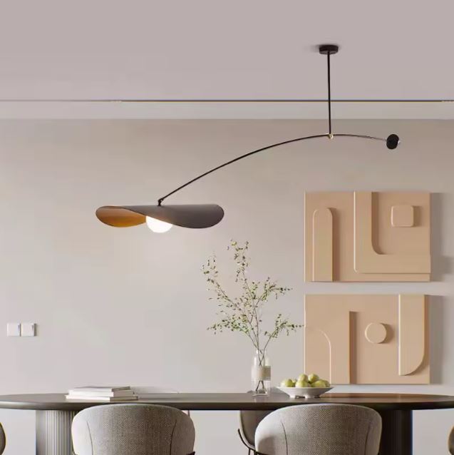 Suspension déportée noire et dorée au-dessus d’une table, dans un style contemporain et élégant.