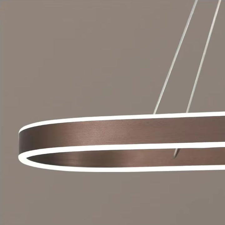 Détail du profil arrondi d'une suspension ovale finition café brossé, avec bande LED lumineuse et esthétique minimaliste.