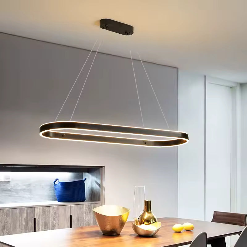 Au-dessus d'une table en bois, suspension LED à anneau ovale allongé finition café, au style contemporain raffiné.