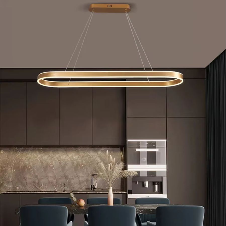 Élégante suspension dorée à anneau ovale allongé, au style contemporain chic, éclairant une salle à manger aux tons sombres.