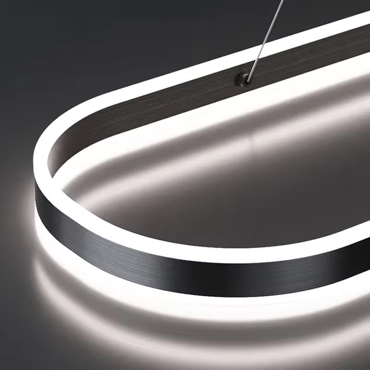 Gros plan sur la finition noire brossée et l'éclairage LED intégré d'une suspension à anneau ovale au design épuré.
