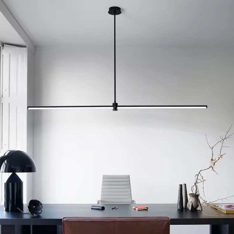 Une suspension linéaire LED noire au profil ultrafin surplombe un bureau épuré, dans un esprit moderne et minimaliste.