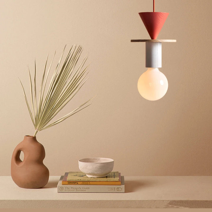 Suspension lumineuse géométrique en bois coloré avec abat-jour conique rouge au style moderne.