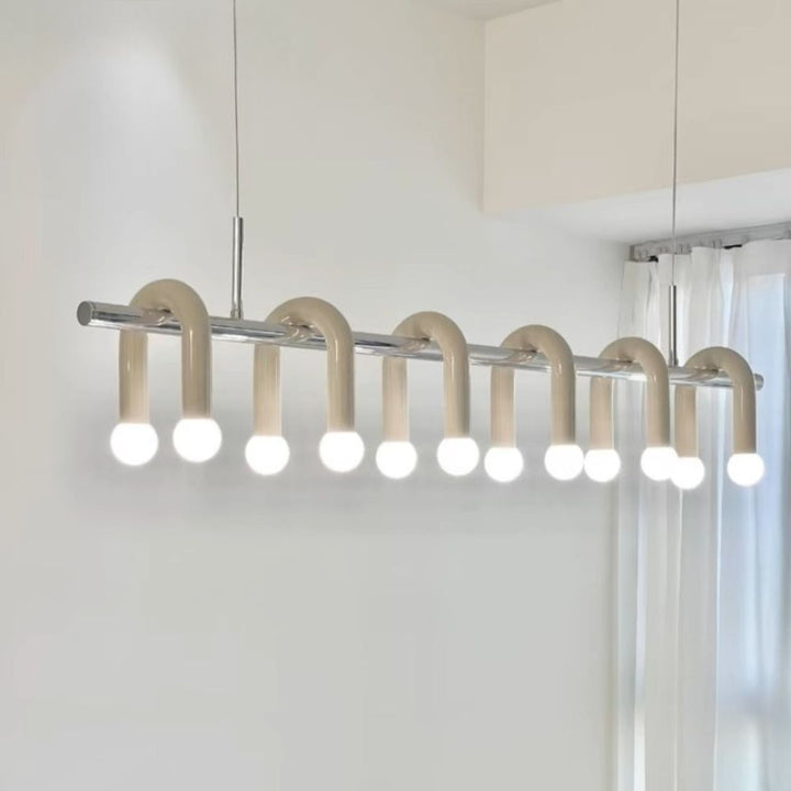 Suspension design ton crème à arches et globes lumineux suspendue dans un espace de vie chaleureux.