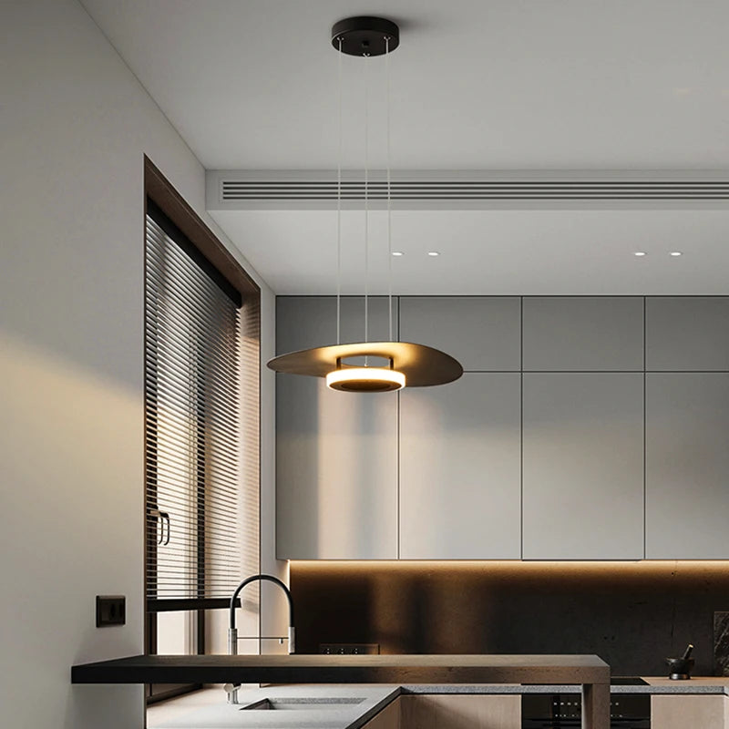 Suspension design en forme de disque avec halo lumineux dans un salon moderne aux tons neutres.