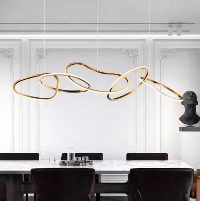 Suspension design italien haut de gamme avec des lignes sculpturales dorées, idéale pour une salle à manger aux détails architecturaux raffinés.