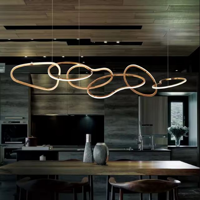 Suspension design italien haut de gamme avec des lignes dorées, parfaitement intégrée dans une cuisine moderne aux tons bois et noir.