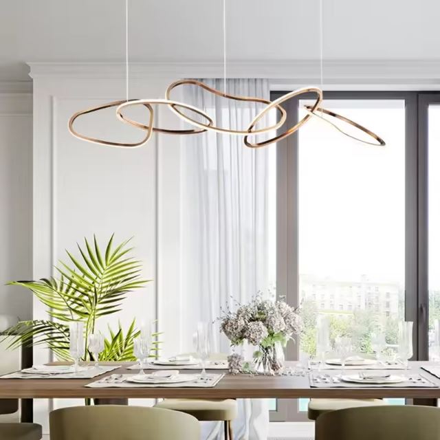 Suspension design italien haut de gamme avec des lignes élégantes dorées, idéale pour sublimer une salle à manger lumineuse et moderne.