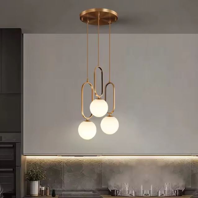 Suspension design en laiton avec 3 globes opaline, style art déco moderne, luminaire élégant cuisine ou salle à manger.