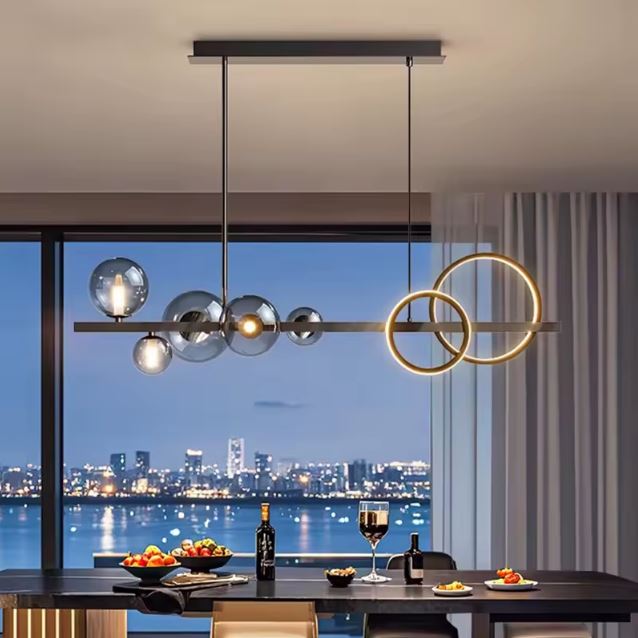Suspension design avec anneaux LED et globes en verre fumé, créant un éclairage élégant dans une salle à manger contemporaine offrant une vue panoramique.