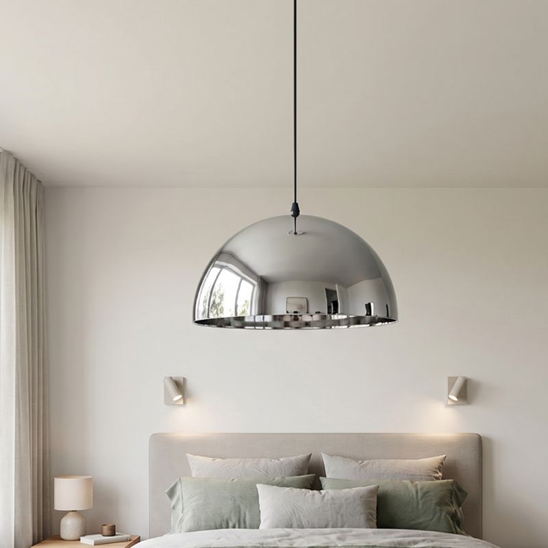 Ambiance apaisante avec une suspension dome moderne centrée au-dessus d'un lit double.