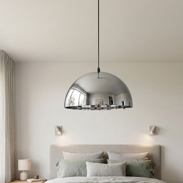Ambiance apaisante avec une suspension dome moderne centrée au-dessus d'un lit double.