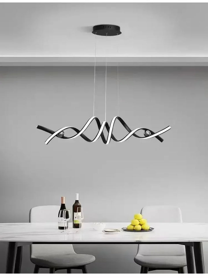 Élégante suspension design au fini noir mat, apportant un éclairage doux au-dessus d'une table épurée.
