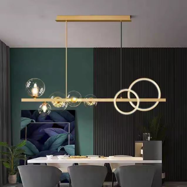 Suspension design dorée avec anneaux LED et globes en verre transparent, apportant une touche élégante italienne et contemporaine à une salle à manger moderne aux tons raffinés.