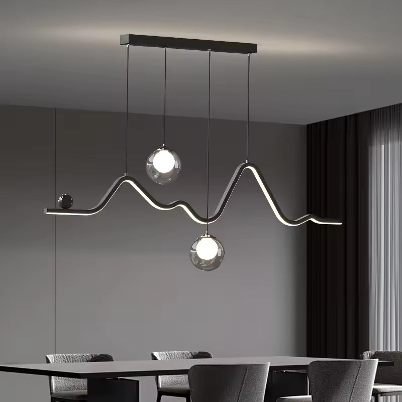 Une suspension à ligne LED ondulée et deux globes en verre illumine une salle à manger au style moderne et sculptural.