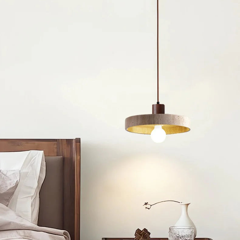 Suspension design en travertin et bois foncé installée au-dessus d'une table de chevet dans une chambre élégante.