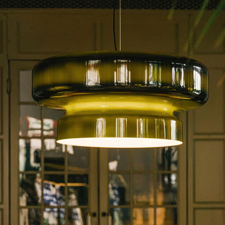 Suspension design en verre fumé vert créant une ambiance feutrée et élégante en soirée.