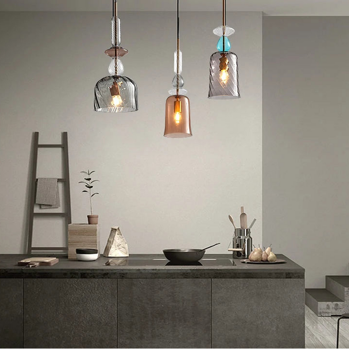 Suspensions décoratives en verre soufflé et détails dorés dans une cuisine au style industriel chic.