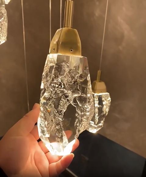 Gros plan sur un pendentif suspension diamant en verre type cristal, révélant la taille texturée et son éclat lumineux.