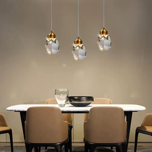 Suspension diamant moderne en cristal et finitions dorées pour une salle à manger chic.