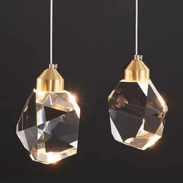 Double suspension diamant en cristal et doré pour un éclairage élégant et moderne.