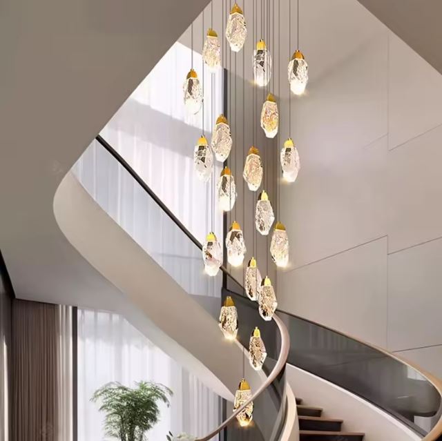 Suspension diamant en spirale lumineuse, des pendentifs cristallins qui magnifient l’escalier d’un intérieur contemporain et luxueux.