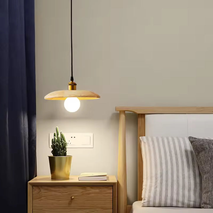 Près du lit, cette suspension en bois clair à globe lumineux crée une ambiance japandi douce, naturelle et apaisante