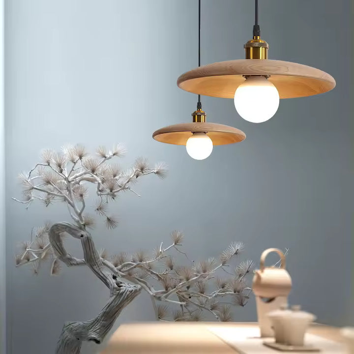 Disque en bois naturel et globe lumineux composent une suspension au style japandi, minimaliste et chaleureux