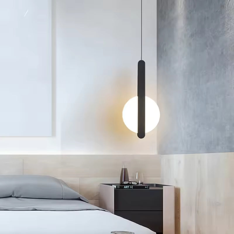 Suspension disque lumineuse noire au-dessus d’un chevet dans une chambre contemporaine au style épuré
