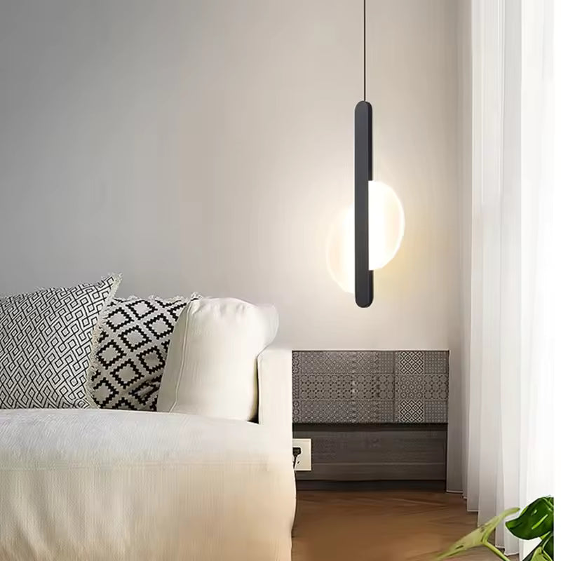 Suspension disque lumineuse noire près du lit dans une chambre moderne au style graphique et minimaliste
