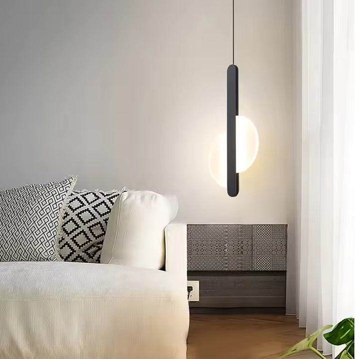 Suspension disque lumineuse noire près du lit dans une chambre moderne au style graphique et minimaliste