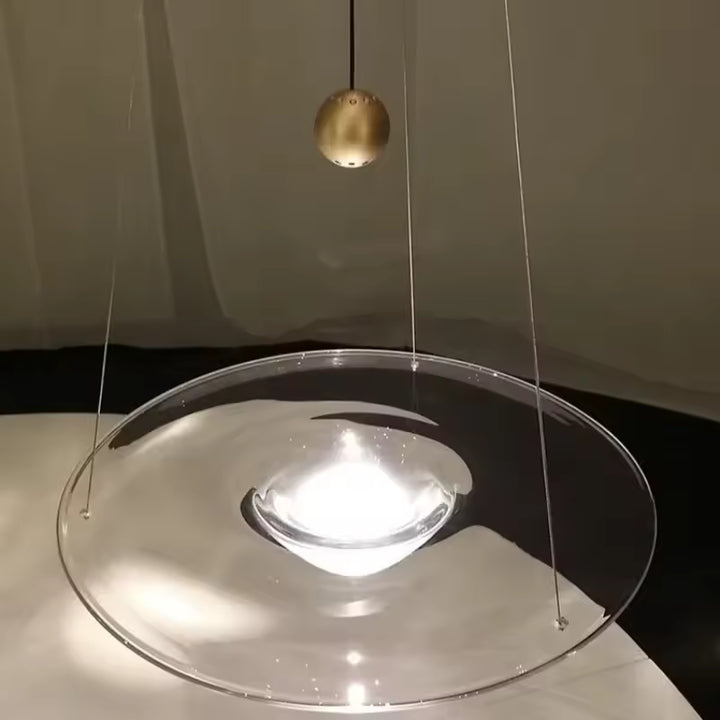 Détail d’une suspension disque en verre avec cœur lumineux en goutte, au design sculptural et contemporain