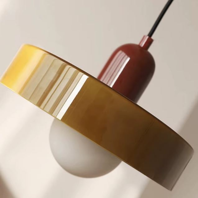 Gros plan sur une suspension disque kaki et brun, esthétique vintage raffinée et design rétro élégant.