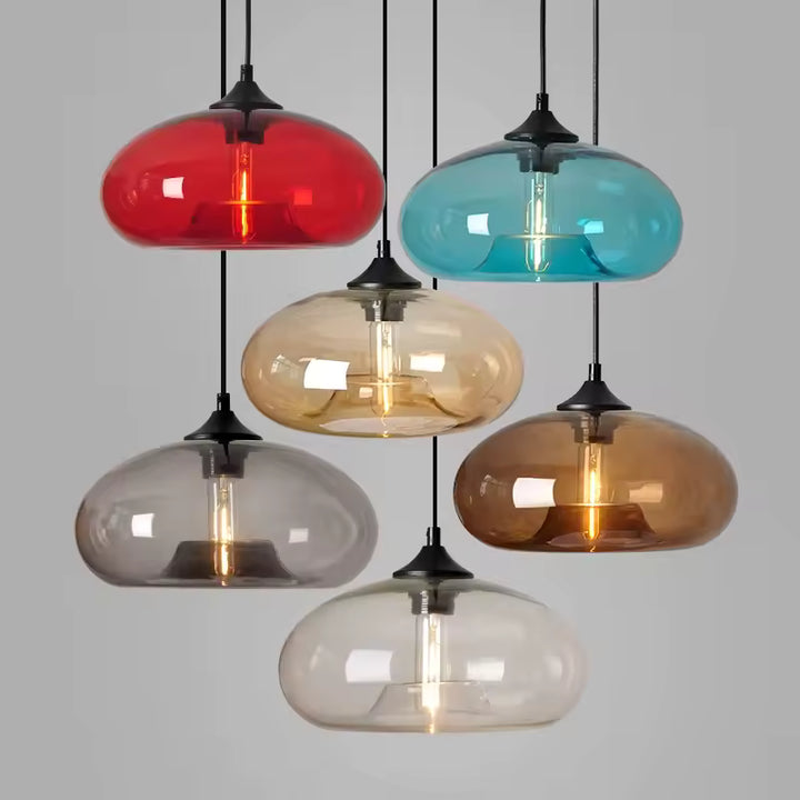 Déclinée en plusieurs verres colorés, cette suspension au dôme aplati affiche un style rétro, pop et contemporain