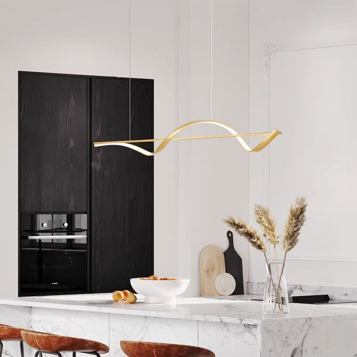 Suspension dorée luxueuse apportant une touche chaleureuse et design dans une cuisine ouverte.