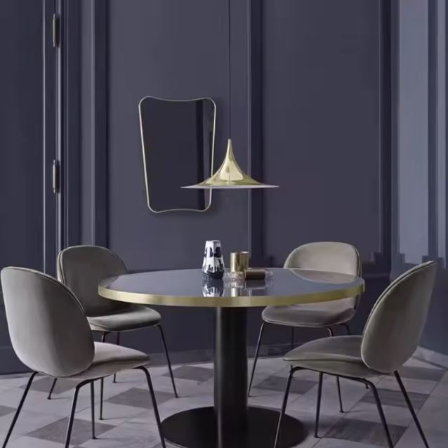 Suspension dorée au-dessus d’une table ronde, entre design italien, raffinement vintage et élégance moderne.