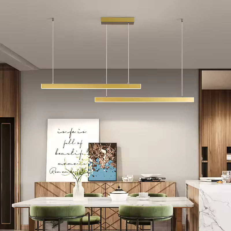 Dans une salle à manger contemporaine, la suspension double barre LED dorée apporte une touche élégante et minimaliste