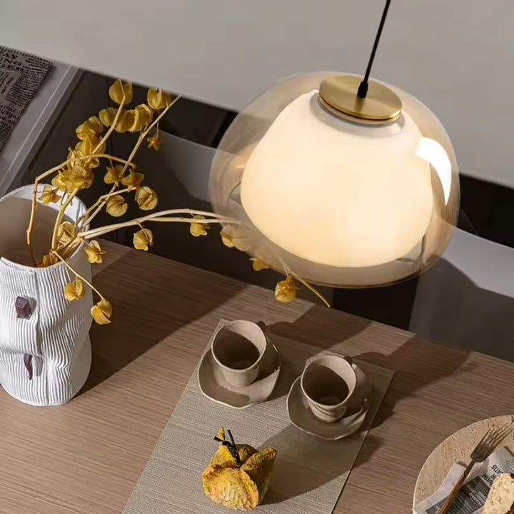 Suspension double cloche en verre et cœur opalin au design contemporain élégant au-dessus d’une table