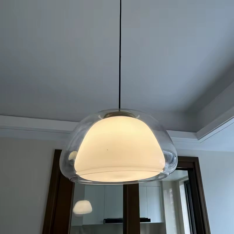 Vue rapprochée d’une suspension à double cloche en verre clair et cœur opalin au design doux et contemporain