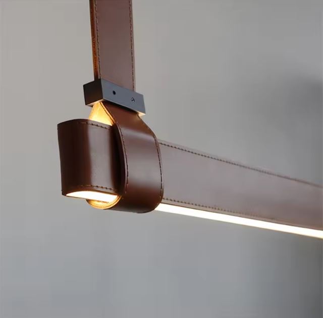 Gros plan sur la suspension en cuir marron avec éclairage LED, mettant en avant ses finitions raffinées et son design luxueux.