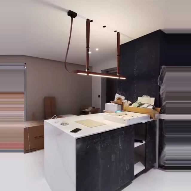 Suspension en cuir marron avec éclairage LED, installée au-dessus d’un îlot de cuisine, ajoutant une touche moderne et raffinée.