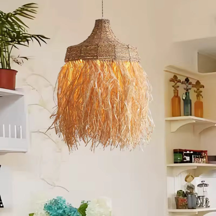 Suspension en raphia illuminée à longues franges dans un intérieur bohème au charme méditerranéen