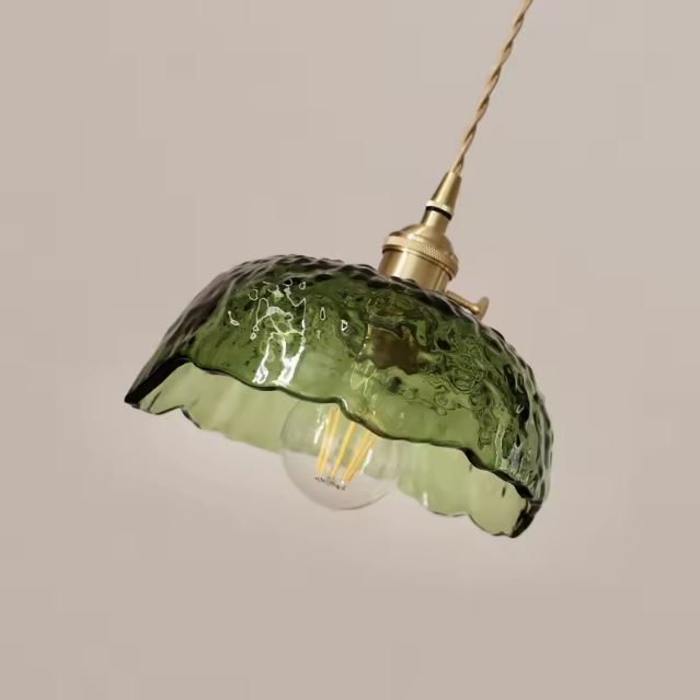 Suspension en verre vert soufflé au design artisanal, parfaite pour une ambiance naturelle et élégante dans la maison.